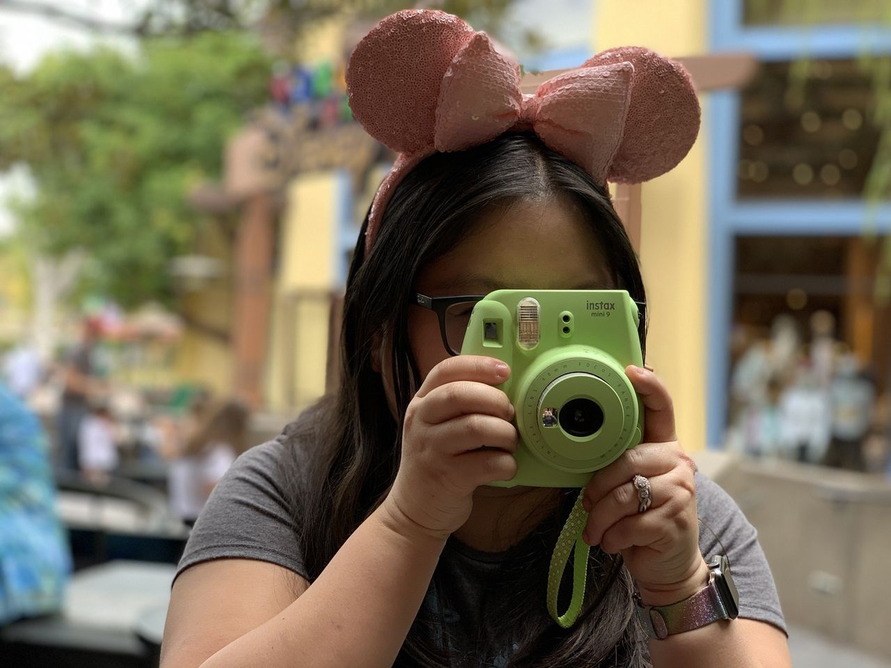 Christine Chan snaps a photo with her Green Fujifilm Instax Mini 9 camera