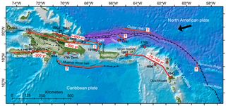 Multiple faults crisscross the eastern Caribbean. Those outlined in red have a potential to generate a large earthquake. The arrow at top right shows the direction of the North American plate’s motion relative to the Caribbean plate. Red stars denote intensity centers for past earthquakes.