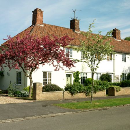 row of white terraced houses with red tile roofs