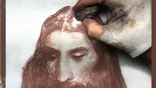 Charcoal drawing: hand using eraser to rub out hair from a painting of a man's face