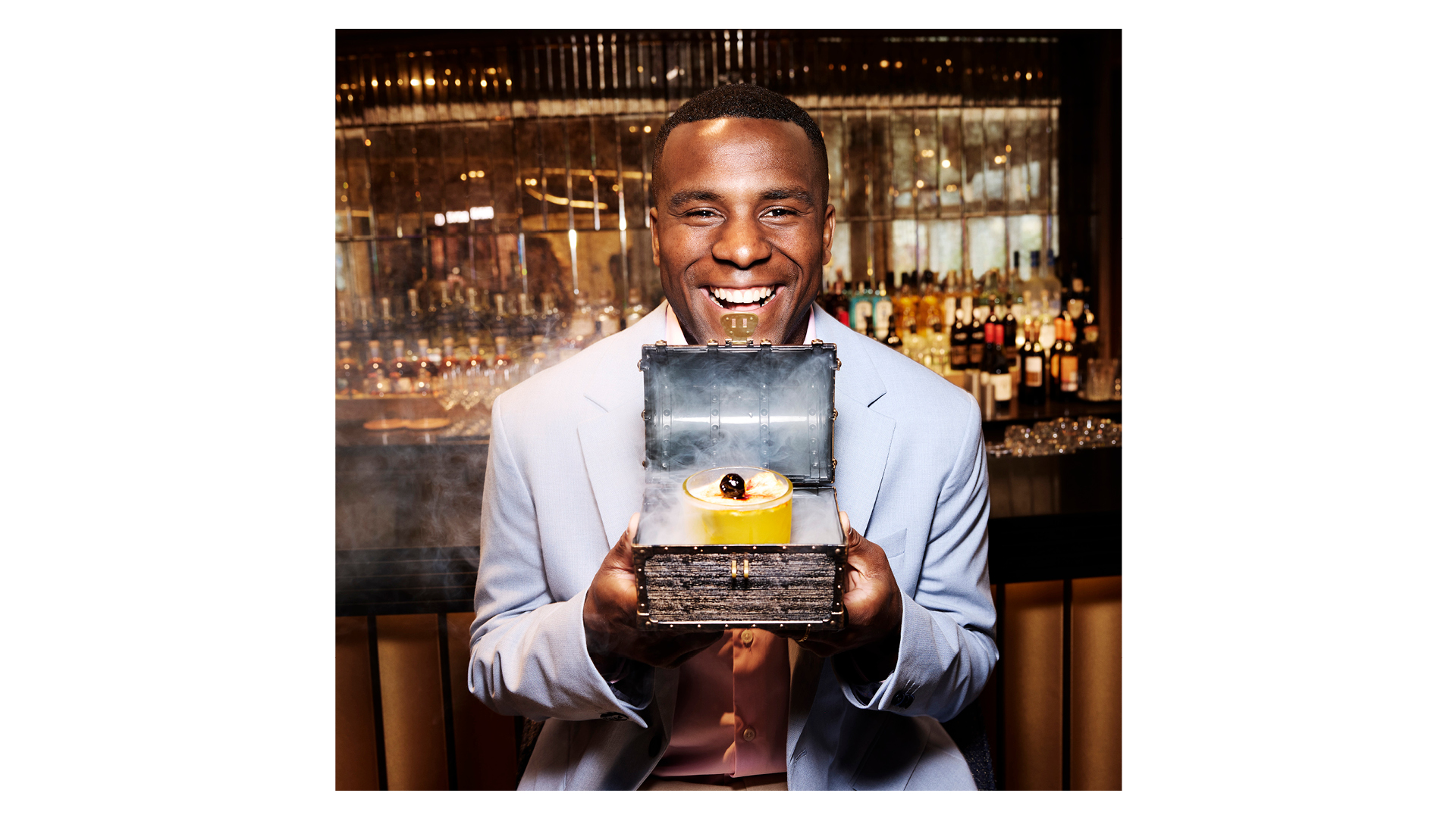Photograph of a male model holding a box containing a dessert, with smoke escaping from it, taken by British photographer Rankin as part of a creative collaboration with cruise line operator P&amp;amp;O Cruises titled On Board with Rankin
