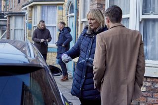 Eileen and Todd grow suspicious of Laurence as they chat out on the cobble by a car