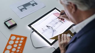 Man using lightbox to trace an image onto paper: Best lightbox for drawing and tracing