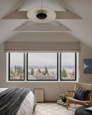 bedroom with beams and vaulted ceiling white walls and view through big window