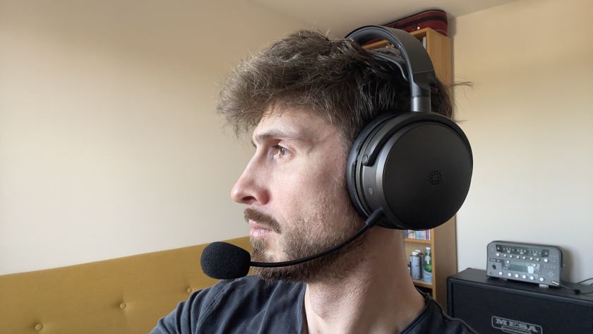 A man wearing the Audeze Maxwell 2 gaming headset showing the left side of his face and the left ear cup and microphone.