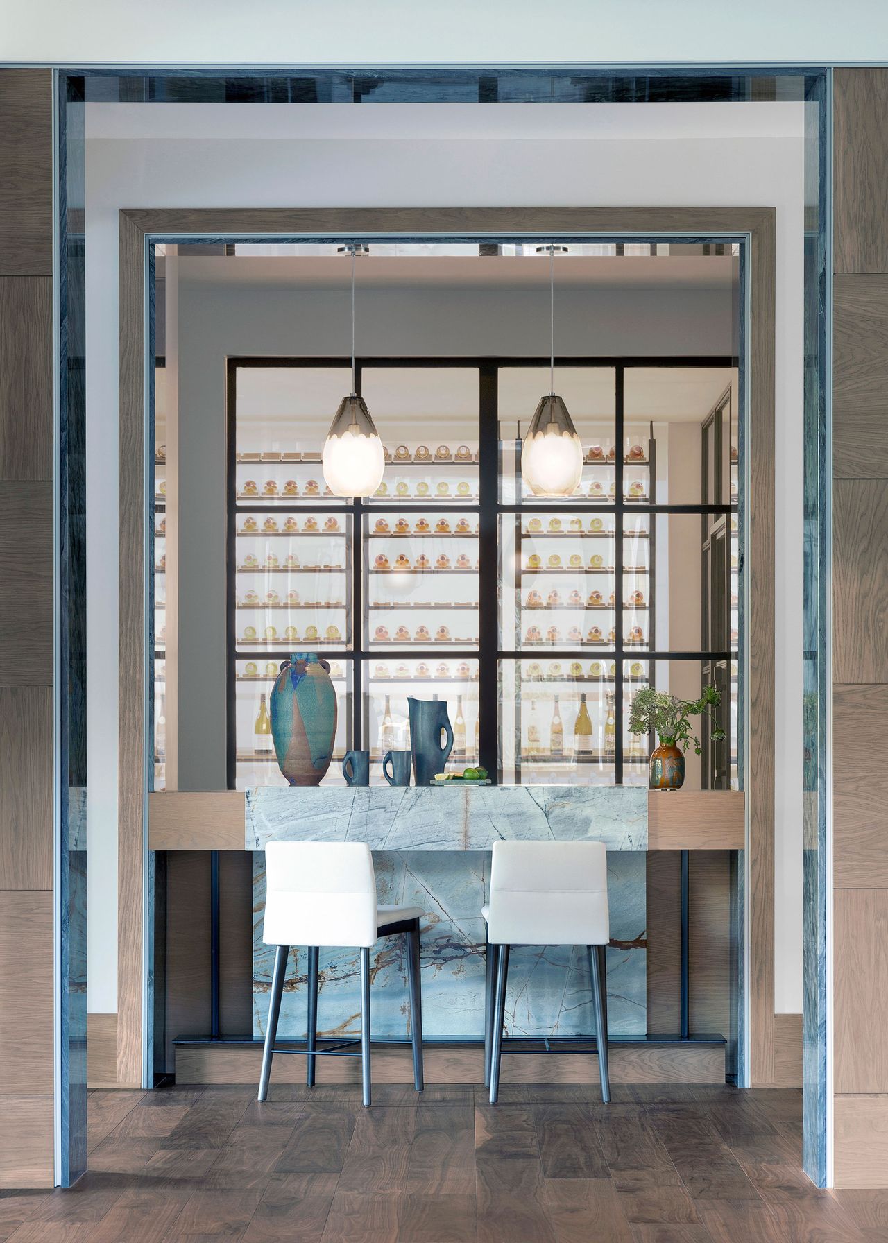 kitchen island with marble insert and white bar stools with window through to wine cellar
