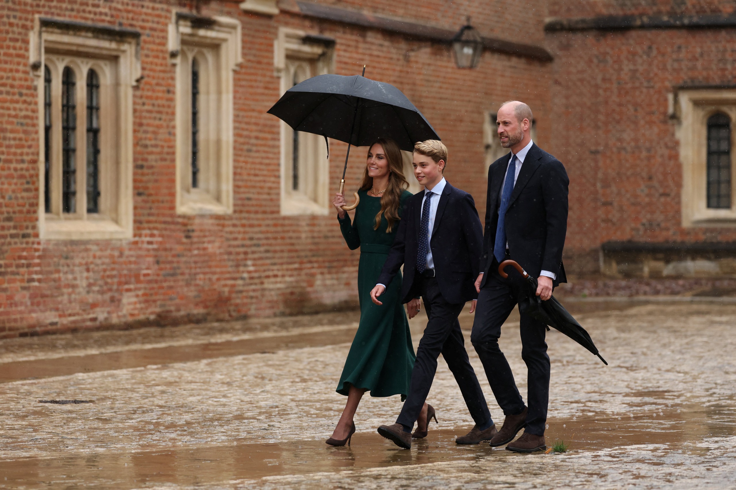 Princess Kate, Prince William and Prince George under an umbrella at Eton College