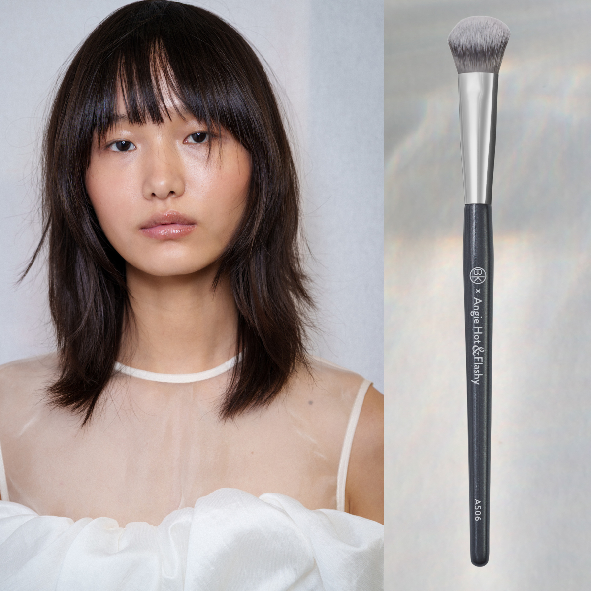 A woman with short hair and bangs wearing a sheer white mesh shirt. She is next to a makeup brush. 