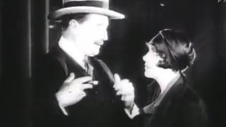 A man and a woman talking to each other in black and white in The Pleasure Garden