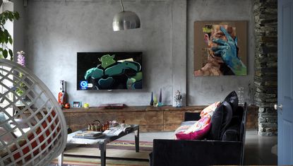  a large flatscreen TV on grey walls in a loft apartment