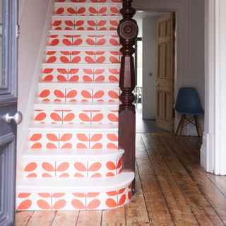 White painted stairs with the risers wallpapered in Orla Kiely wallpaper
