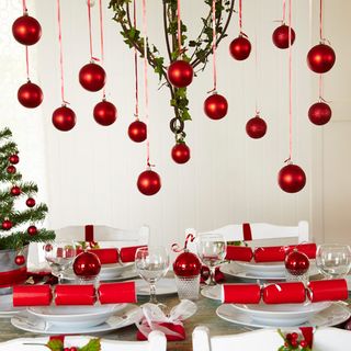 hanging red baubles with festive table setting and 12 piece dinner set