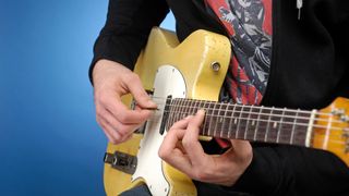 Man playing Fender Telecaster guitar in studio setting