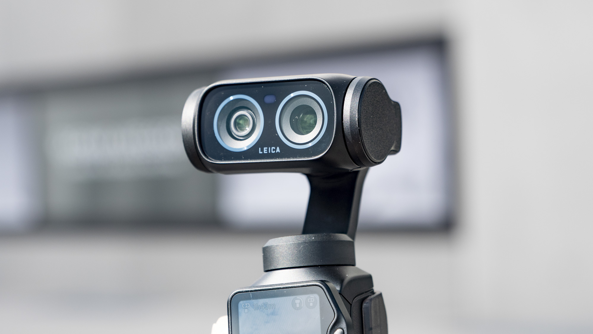 Closeup of the Insta360 Luna Ultra vlogging camera's dual lenses, outdoors in a grey urban scene