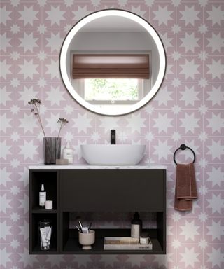pink geometric tiled bathroom with circular mirror opposite window