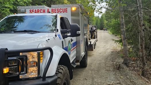 Search and rescue vehicles from Central Okanagan Search &amp; Rescue line up on a dirt road