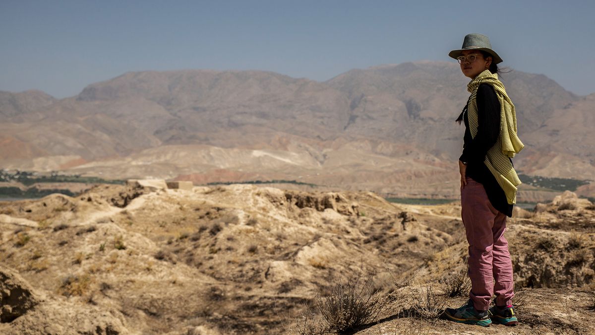 A woman wearing a pair of Patagonia Women’s Hampi Rock Pants turns to look back towards the camera.