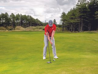 John Howells demonstrating a drill using two different training aids to monitor movement in the golf swing