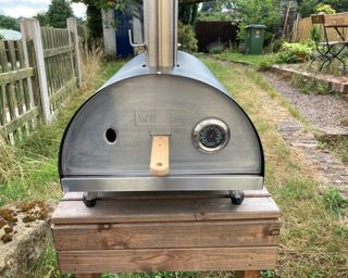 woody pizza oven in garden on small wooden table