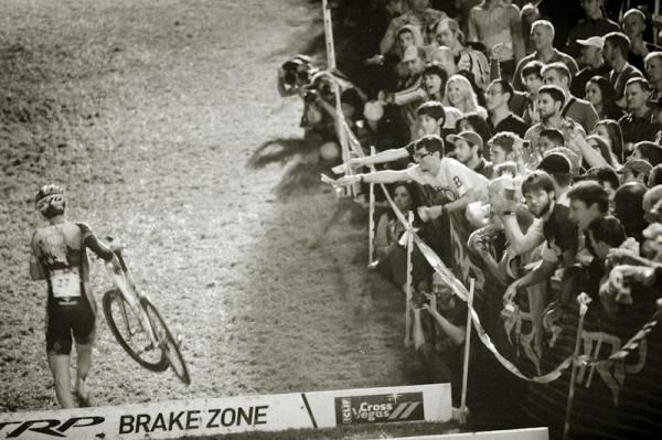 Fans cheer on a rider through the barriers.