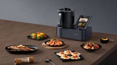 Lifestyle image of the Xiaomi Smart Cooking Robot surrounded by plates of food
