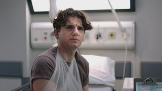 Sean Huddlestan as patient Dane, with his arm in a sling and watching Dylan closely and with suspicion.