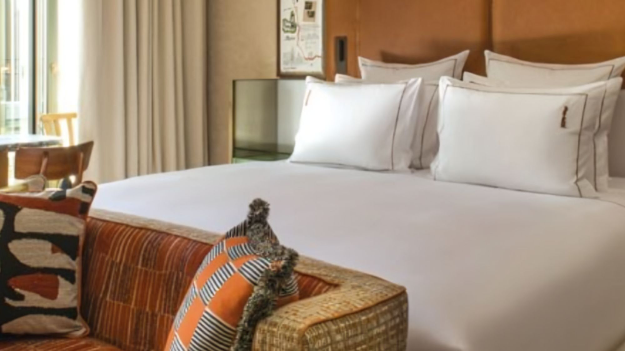 Brach Madrid hotel room with made bed and sofa