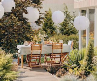 Paper lanterns above a garden table on a deck