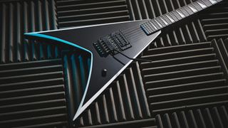 A Jackson Pro Series Signature Wes Borland King V electric guitar lying on a panels of acoustic guitar