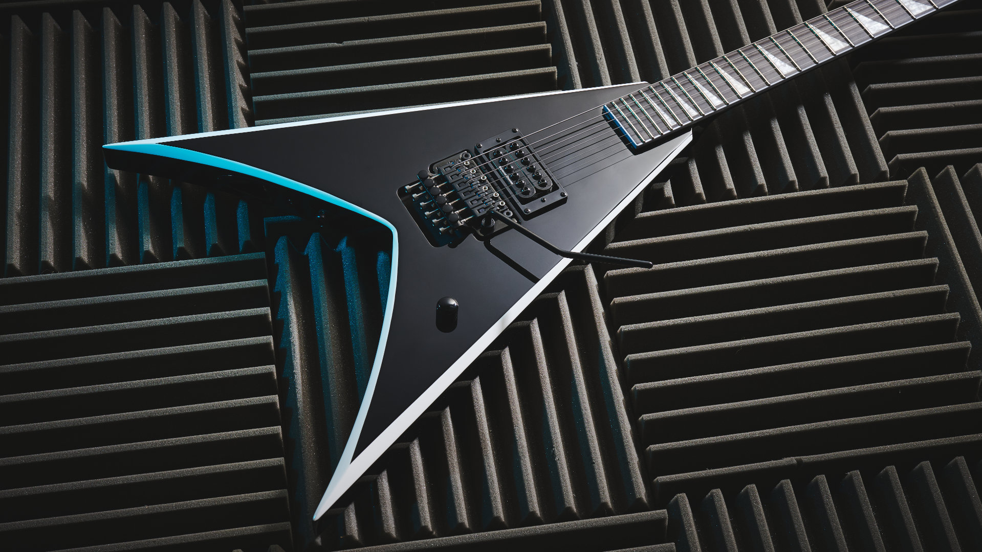 A Jackson Pro Series Signature Wes Borland King V electric guitar lying on a panels of acoustic guitar