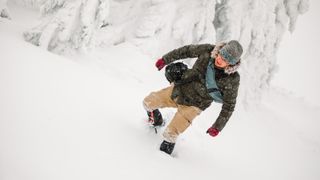 一个人在寒冷的日子里走在积雪覆盖的山上