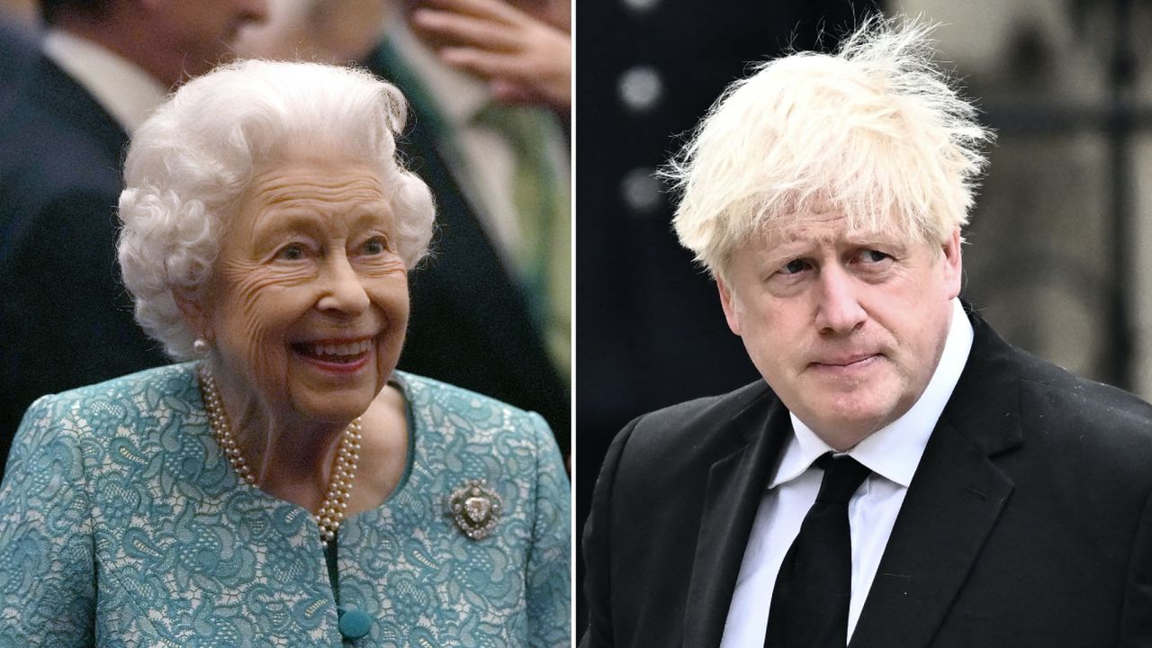 Queen Elizabeth laughs while wearing a turquoise floral embroidered jacket while Boris Johnson looks pensive in a black suit