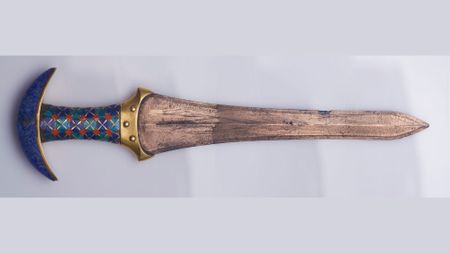 A close up of a blue and brown dagger.