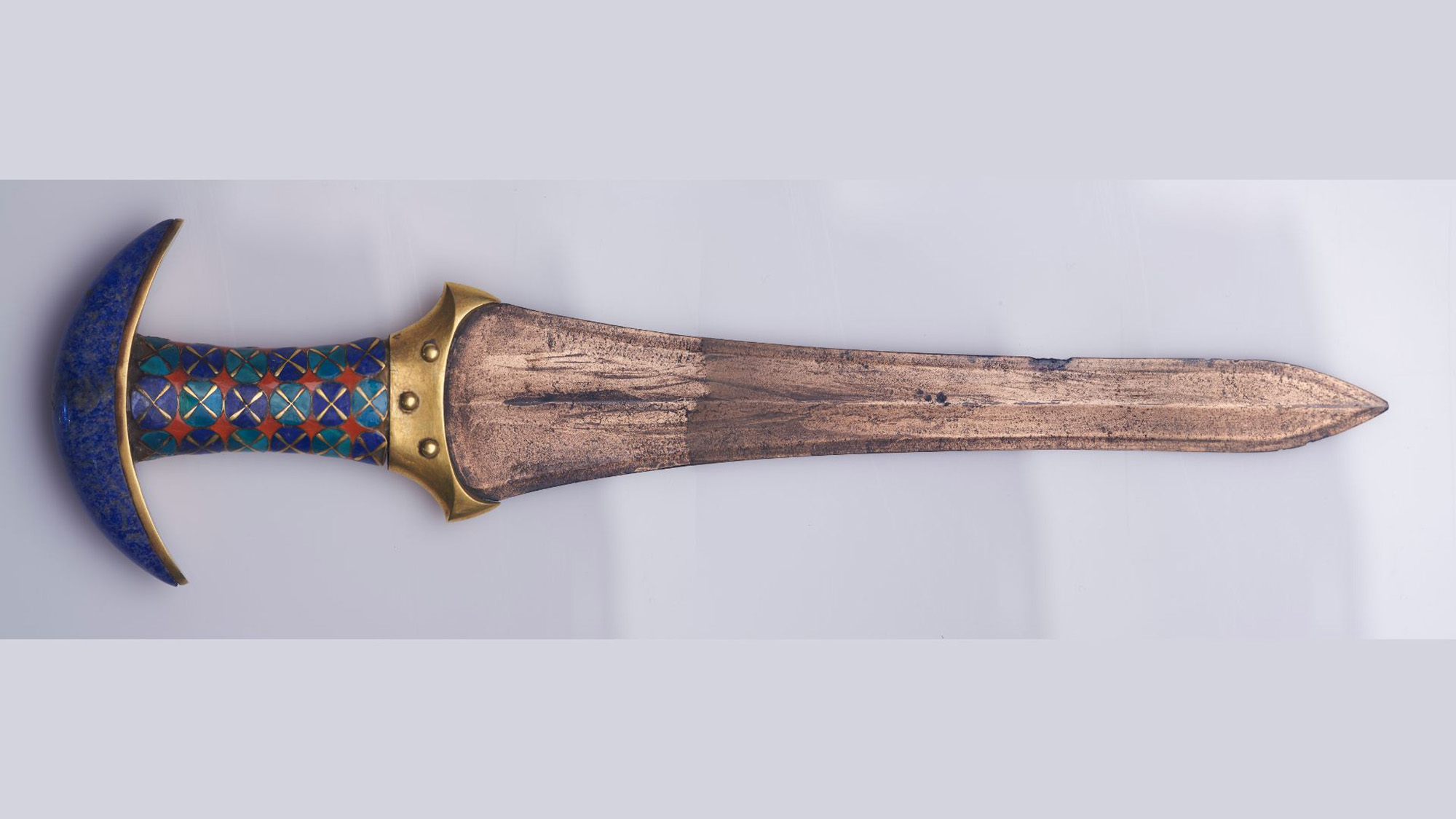 A close up of a blue and brown dagger.