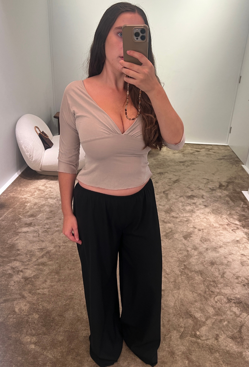 An image of Who What Wear SEO writer Ava Gilchrist wearing The Row Gala pant with a grey three-quarter length top and black loafers.