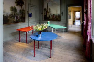 Three colourful tables with a vase of flowers by Muller Van Severen for Hay