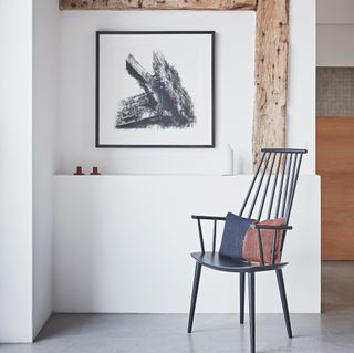 white wall and wooden beam and painting frame and chair