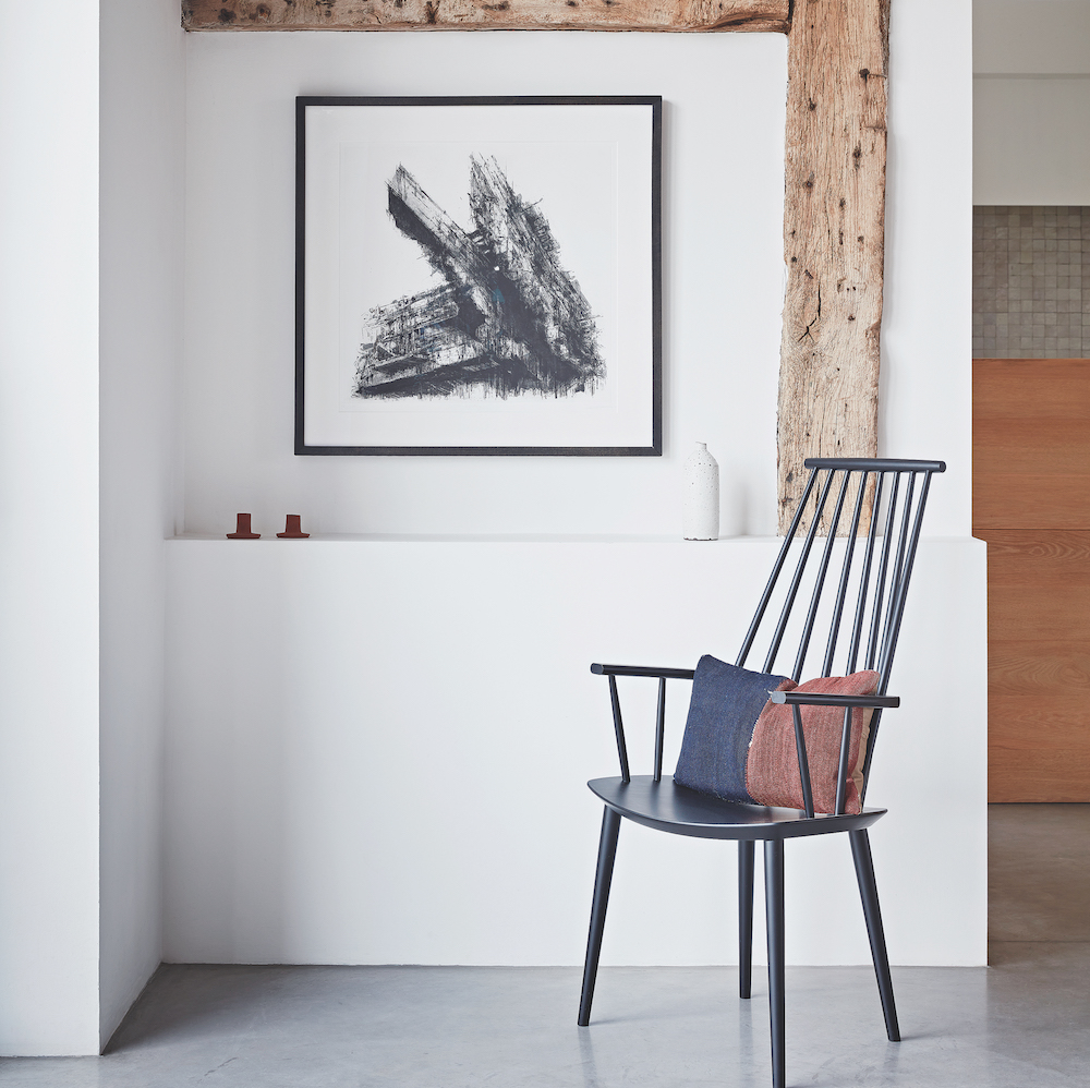 white wall and wooden beam and painting frame and chair
