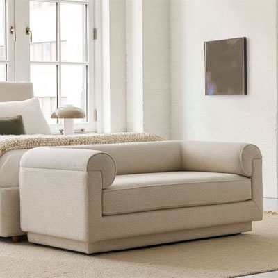curved retro cream sofa in bedroom