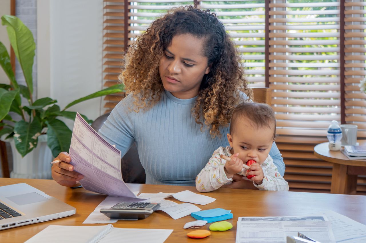 Free childcare: a mother manages the monthly family budget while taking care of her baby