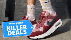 woman wearing Nike Air Max SC SE in red in front of brick building with mid-calf socks on, overlay with Killer Deals badge