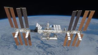 An image of the International Space Station, with its many solar panels and modules, floating above Earth in space