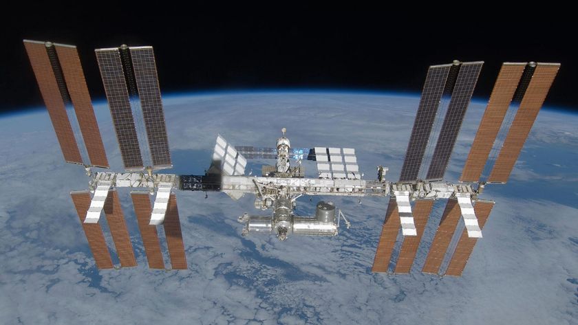 An image of the International Space Station, with its many solar panels and modules, floating above Earth in space