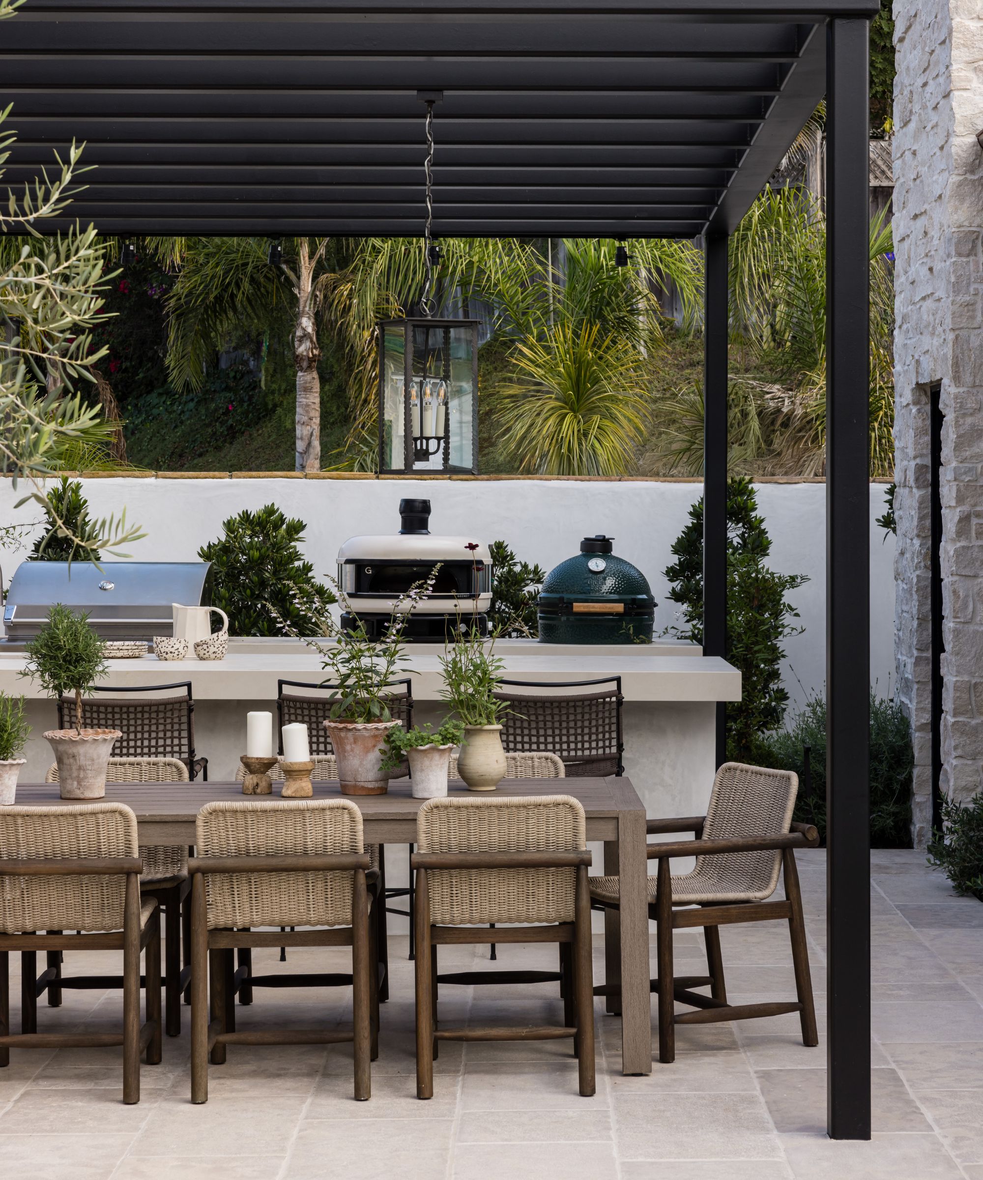 Rustic outdoor dining area under black wooden pergola