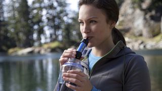 woman drinking from water filter