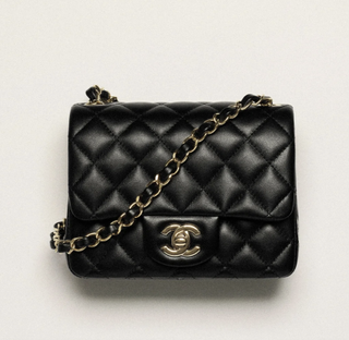 a black chanel flap bag on a plain backdrop