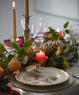 A christmas table decorated with a spruce garland of green foliage and pine cones