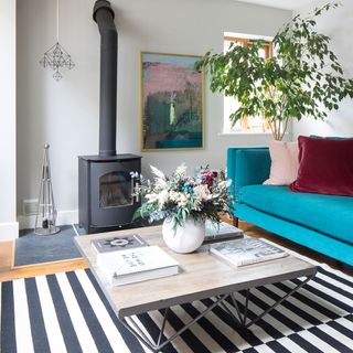 scandi living room with striped rug and blue sofa