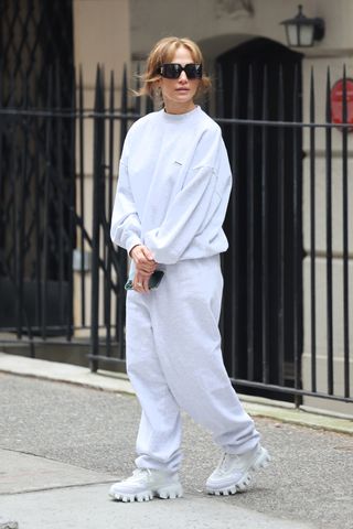 Jennifer Lopez outside her Manhattan apartment wearing a gray sweatsuit and white sneakers