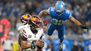 Jayden Daniels #5 of the Washington Commanders scrambles with the ball as Brian Branch #32 of the Detroit Lions dives to apply pressure during the third quarter in the NFC Divisional Playoff at Ford Field on January 18, 2025 in Detroit, Michigan.